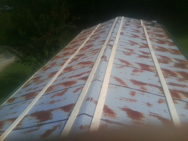 Rusted metal roof panels with new wood purlins before replacement — Storm Damage Roof Repair in Casar by Roofing Brothers
