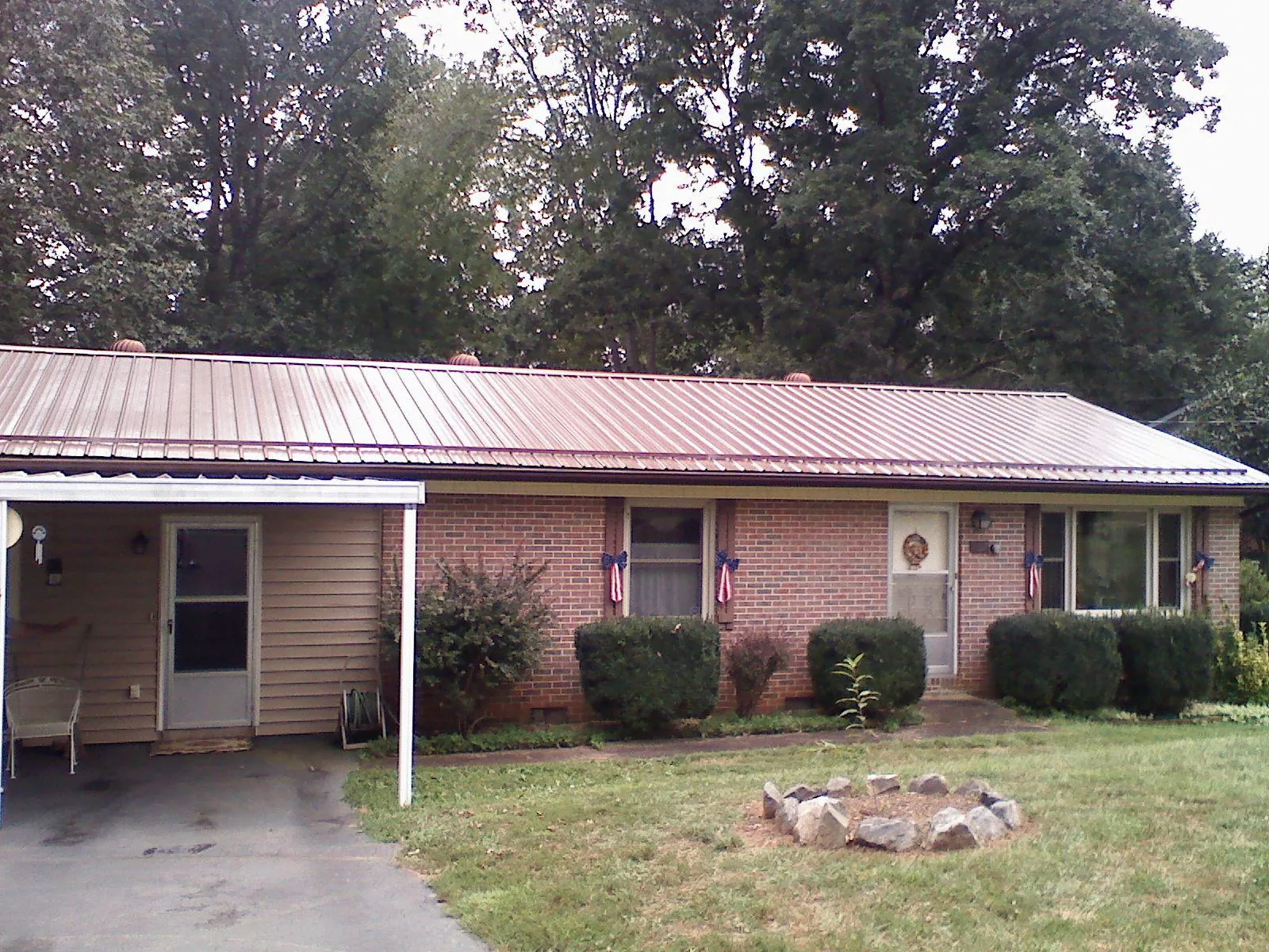 Bronze metal roof and carport on a brick ranch home — Roof Repair work by our crew in Casar