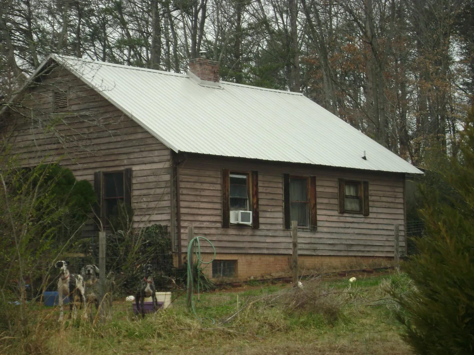 White metal roof on an old wood sided farmhouse, from a Metal Roof Installation job in Casar
